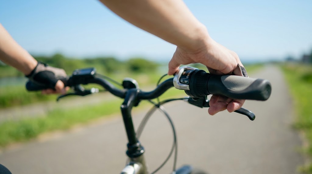 電動アシスト自転車のハンドルを握り、走行中に手元でスムーズに内装変速ギアを切り替える操作の様子